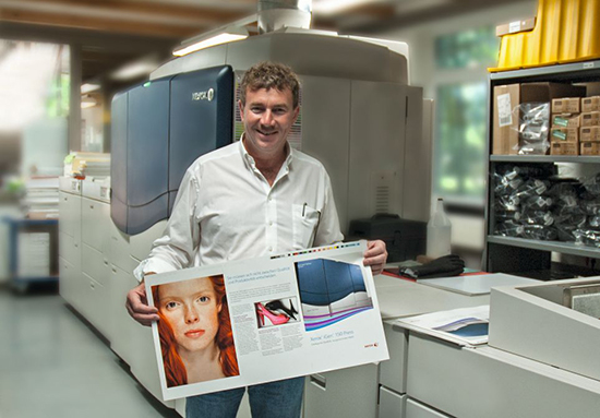 Geschäftsführer Michael Baier mit dem neuen XXL Format vor der Xerox iGen 150
