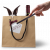 Hase und Weinflasche in mit einem Schild, einer Schleife und einer Klammer versehenen Tüte, davor eine Hand mit Zauberstab 
