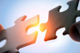 Zwei Puzzleteile werden zu einem Ganzen zusammengefügt